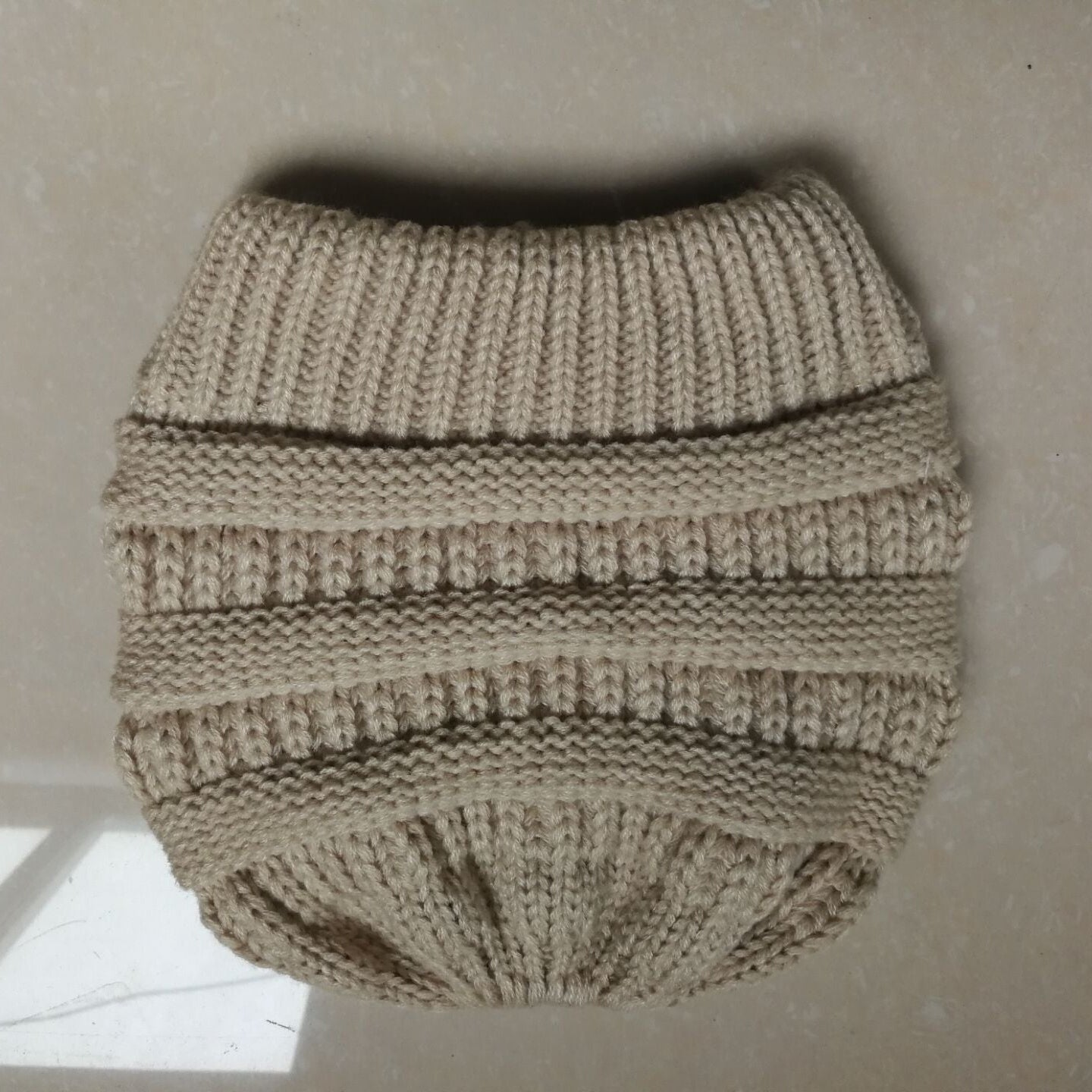 Knitted beige dog sweater on a neutral background