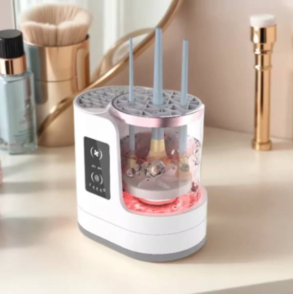 White Electric Makeup Brush Cleaner with pink light on a vanity table