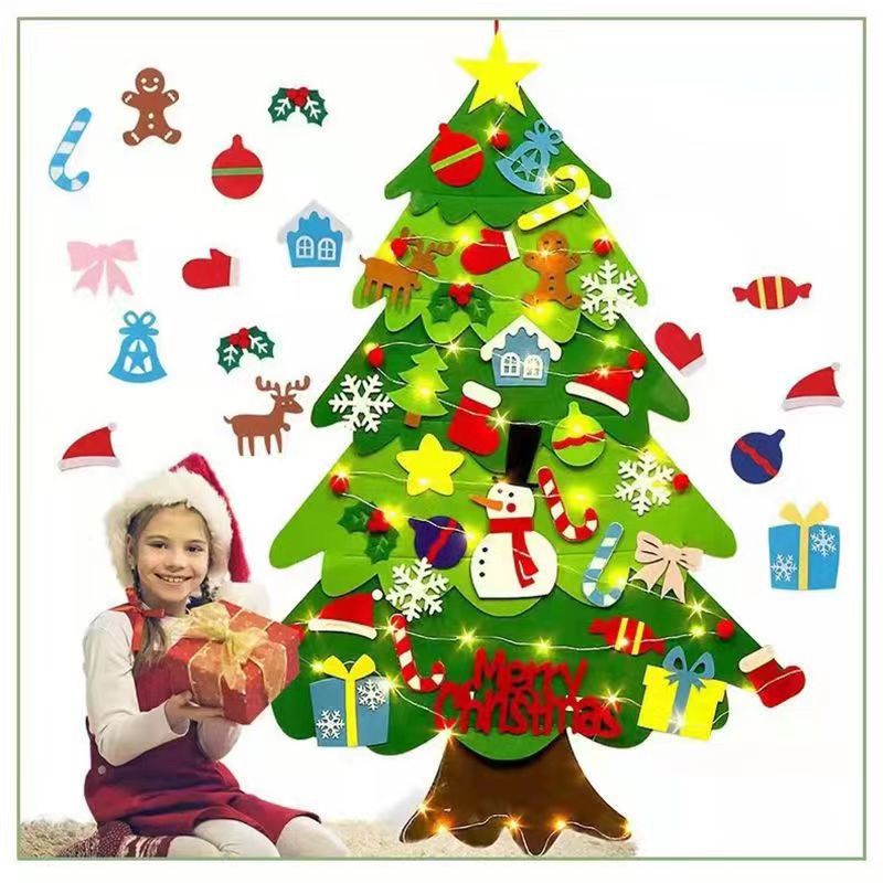 Decorative Christmas tree with colorful ornaments and a child sitting next to it.