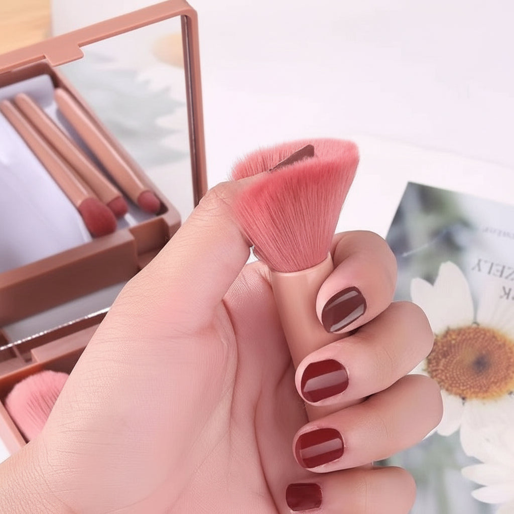 Hand holding a pink makeup brush with a blurred background of makeup products