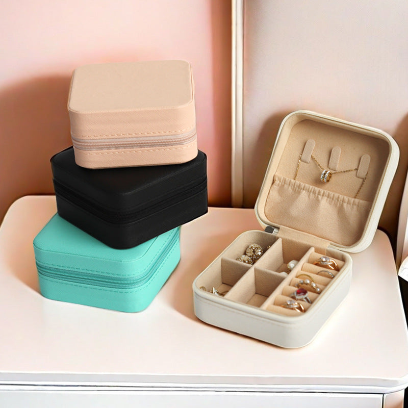 Set of jewelry storage boxes in various colors with one open showing jewelry inside.