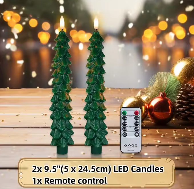 Two LED candles shaped like Christmas trees with a remote control on a wooden surface with festive decorations.