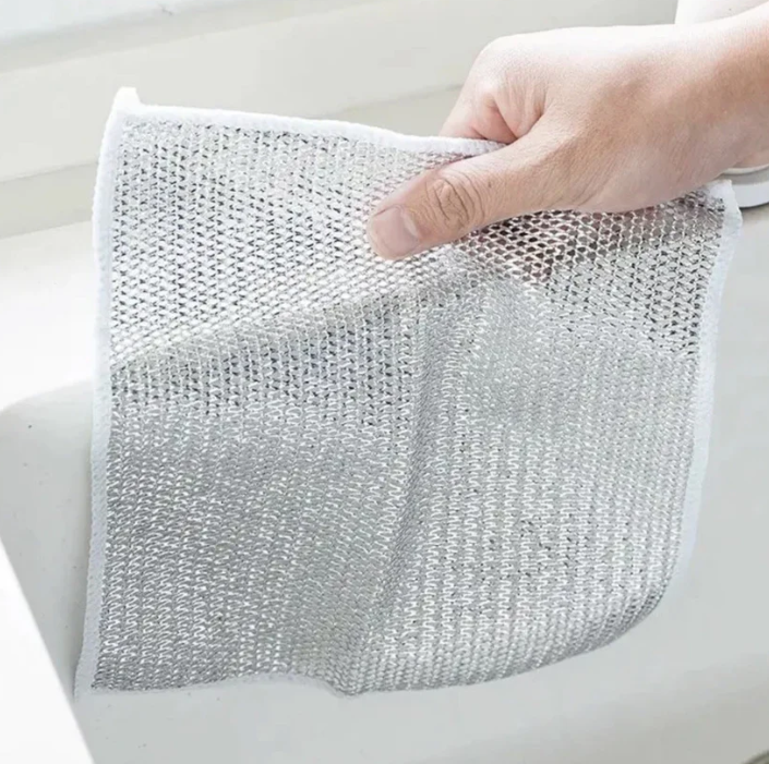 Hand holding a piece of silver mesh against a light background